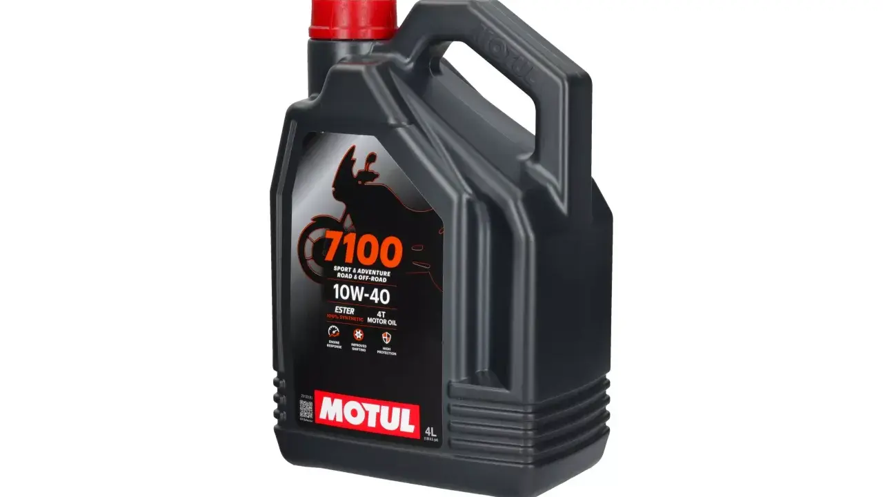 Czarny kanister z czerwonym korkiem, zawierający olej Motul 7100 10W-40.