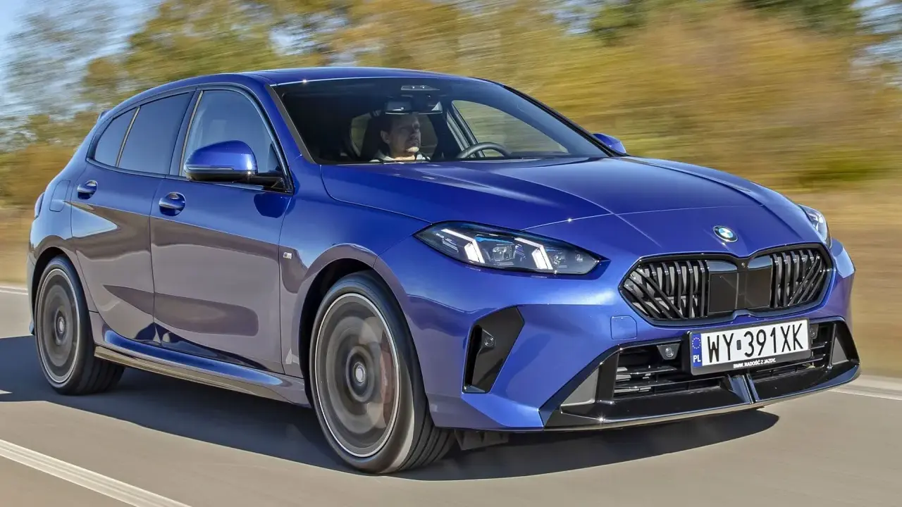 Niebieskie BMW serii 1 (f21) w ruchu, z kierowcą za kierownicą.