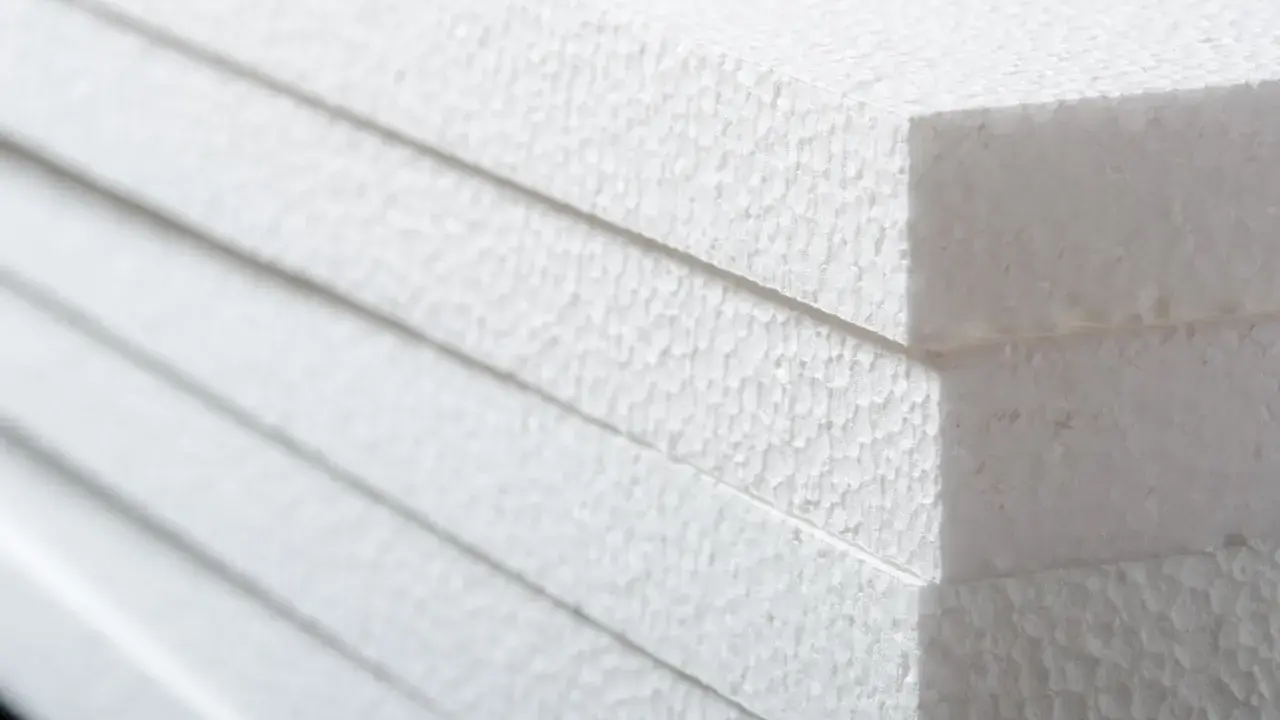 Stapel weißer Styroporplatten, bereit für die Isolierung. Die feine, körnige Textur des Materials ist gut sichtbar.
