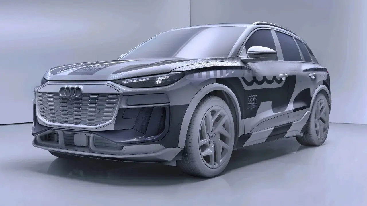 Przyszłościowy Audi Q6 e-tron w szarym kamuflażu, z charakterystycznym grillem i nowoczesnymi światłami LED.