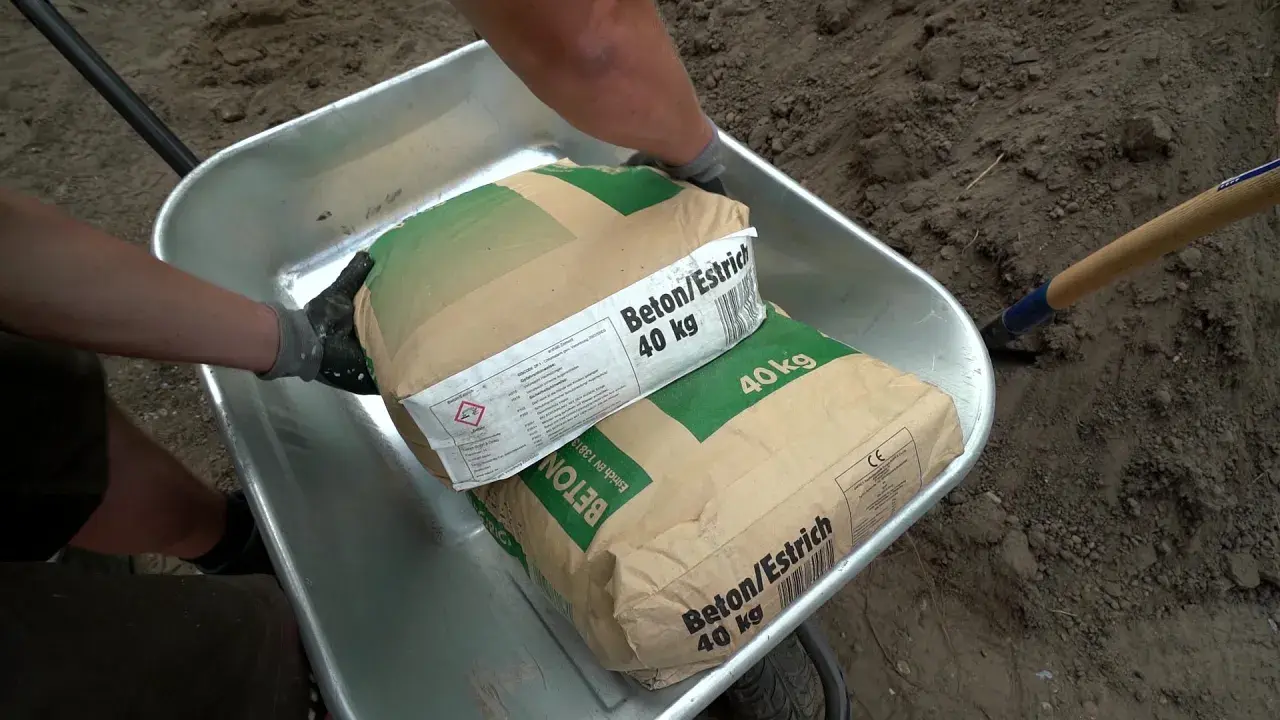 Zwei Säcke Beton/Estrich 40 kg liegen in einer Schubkarre. Verschiedene Estrich Arten sind für Bauprojekte wichtig.