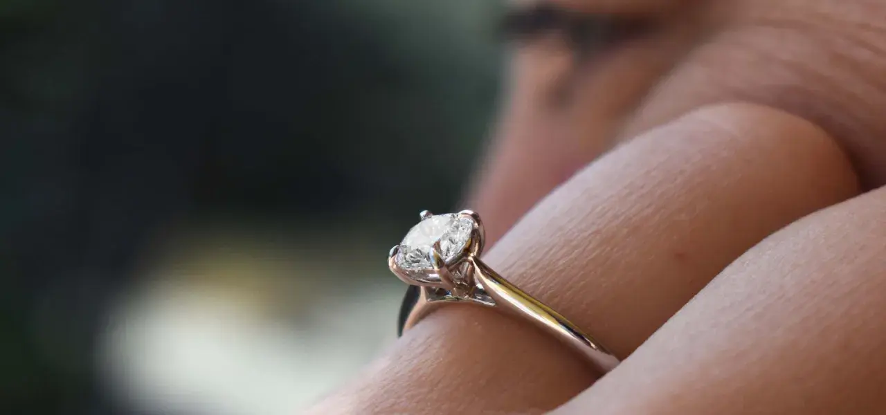 Un anello di fidanzamento con diamante solitario, un classico tra i tipi di anelli di fidanzamento, brilla su un dito.