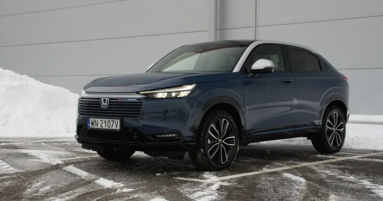 Ciemnoniebieski Honda HR-V na tle śniegu i szarej ściany.