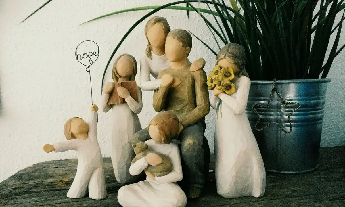 Eine griechische Familie aus Figuren: Vater, Mutter, zwei Mädchen, ein Junge und ein Baby. Ein Mädchen hält ein Buch, ein anderes Sonnenblumen.