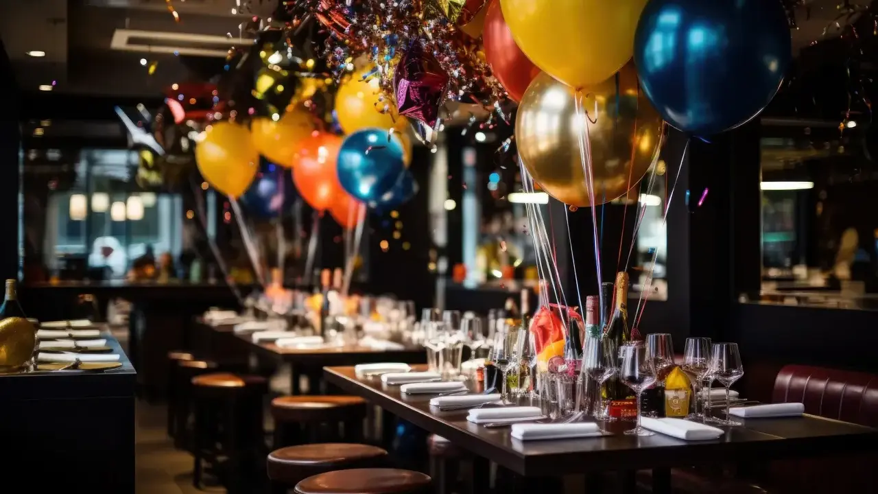 Balony i konfetti ozdabiają stoliki w lokalu, gotowe na 40. urodziny. Zastanawiasz się, ile dać na 40 urodziny w lokalu?