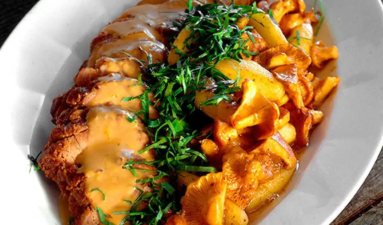 En läcker rätt med stekt kött, krämig sås och nyrensade kantareller, toppad med färska örter.