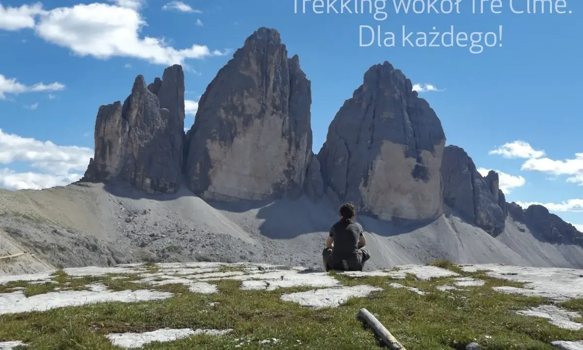 Osoba siedzi na tle majestatycznych Tre Cime, podziwiając widok. Idealne miejsce na trekking!