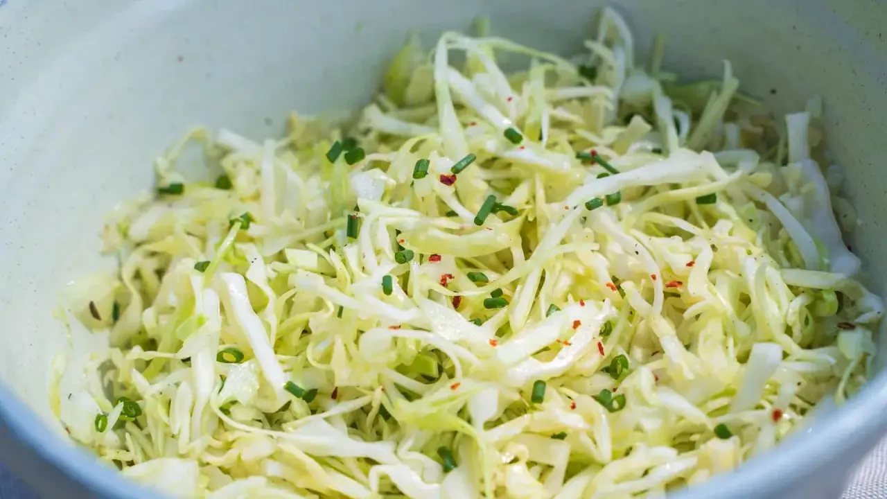 Frischer spitzkohl salat mit Schnittlauch und Chili-Flocken, appetitlich in einer Schüssel angerichtet.