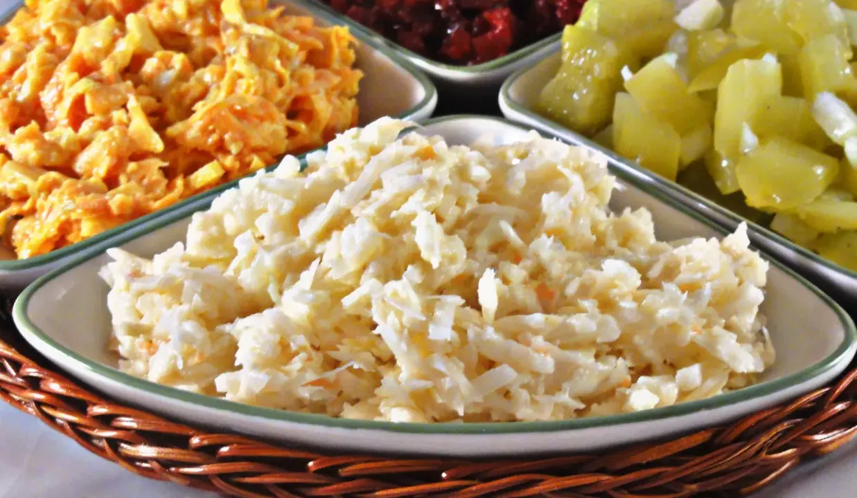 Pyszna surówka z selera, obok innych kolorowych sałatek, czeka na talerzu.