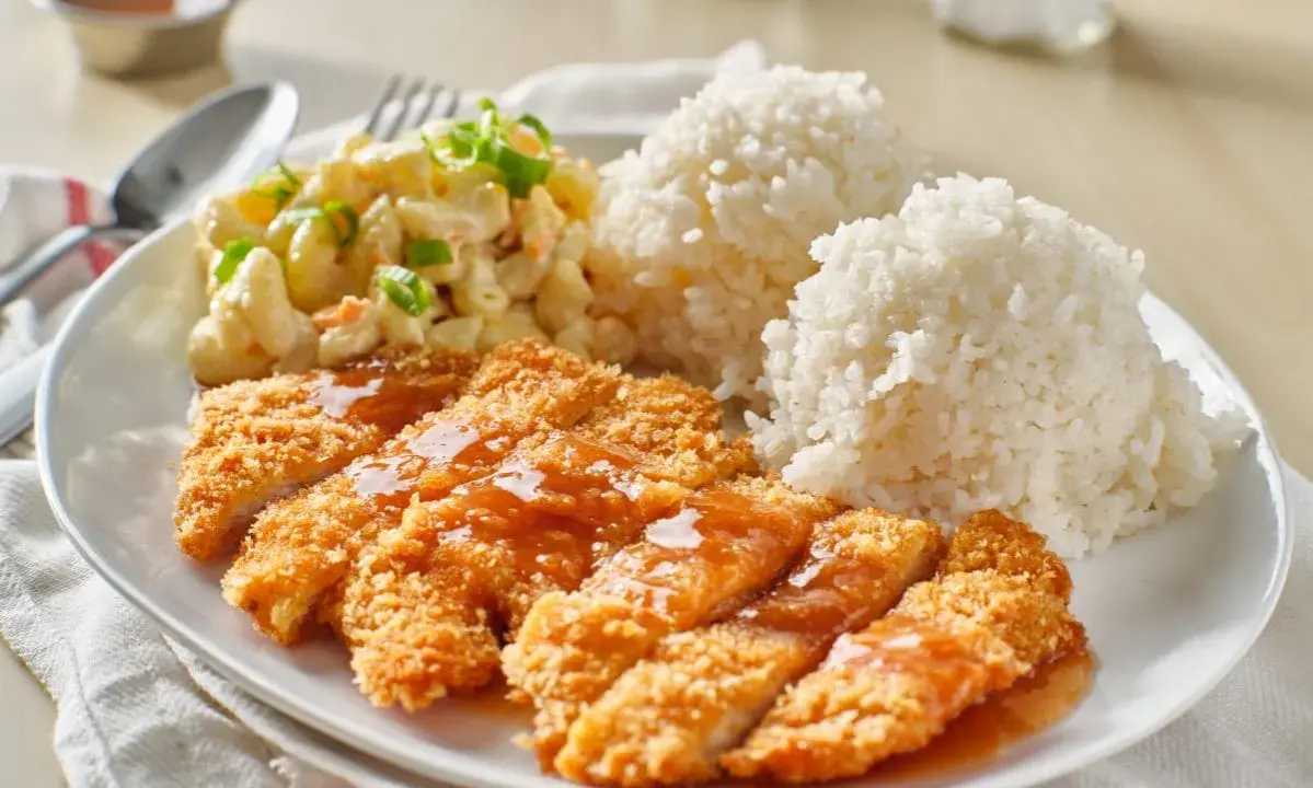 Chrupiący kurczak w panko polany sosem, podany z ryżem i sałatką makaronową. Pyszny obiad!