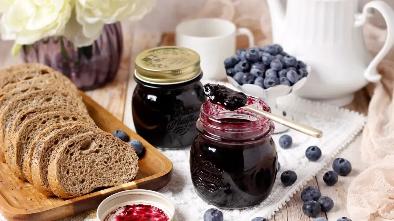 Un petit-déjeuner gourmand avec du pain de campagne, des myrtilles fraîches et une délicieuse confiture de myrtilles.