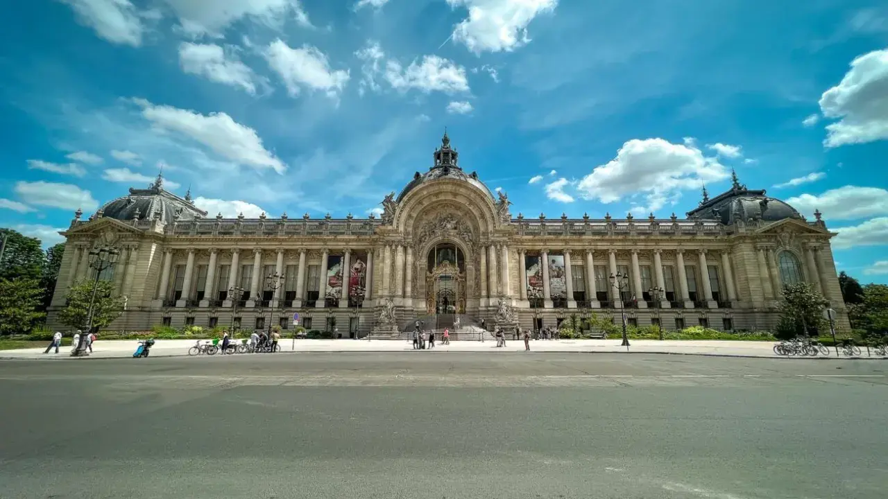 Grand Palais w Paryżu, jeden z najważniejszych zabytków Paryża, z kolumnadą i kopułą pod błękitnym niebem.