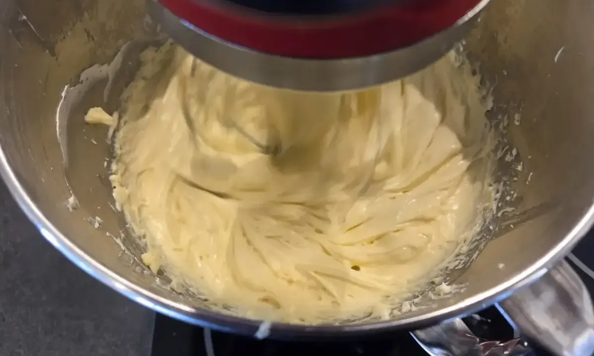 Un robot pâtissier mélange une crème onctueuse, prête à devenir une délicieuse crème mousseline café.