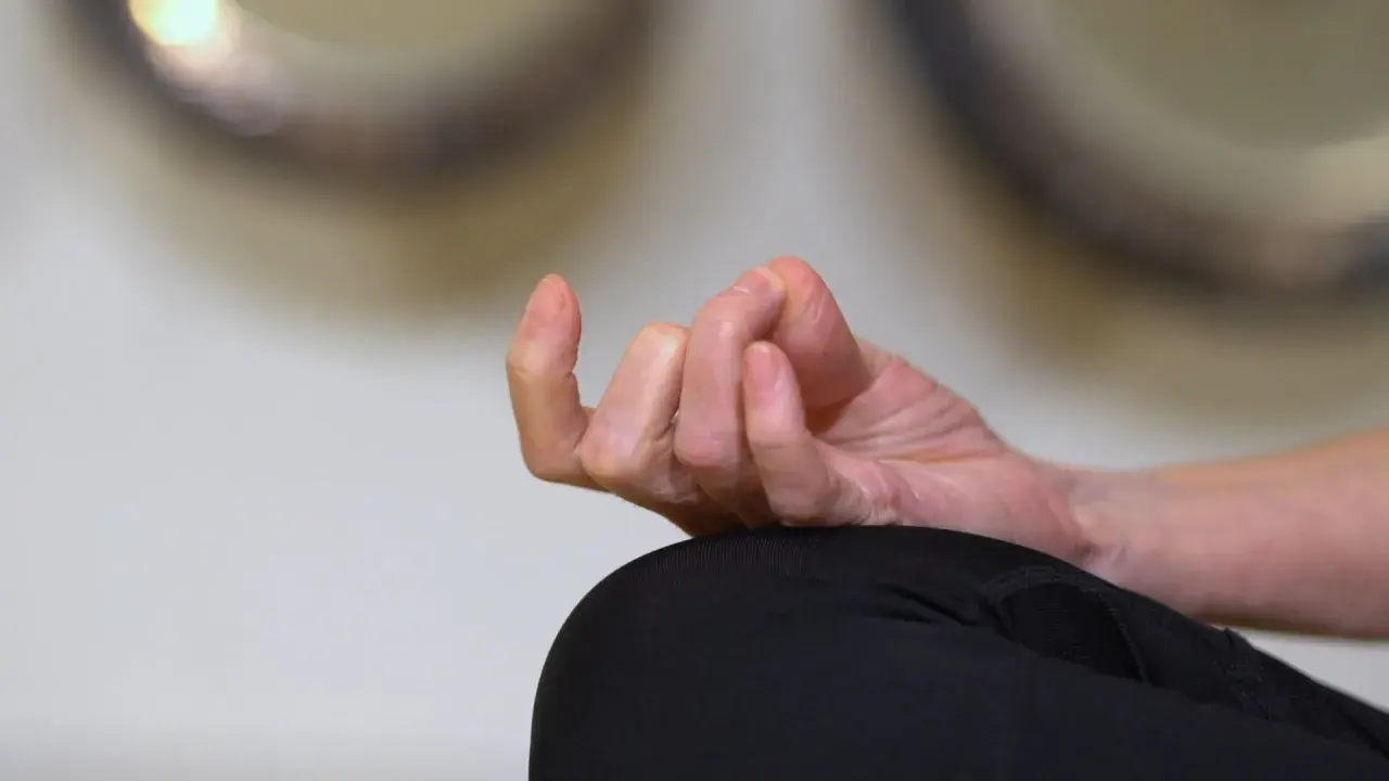 En hand i meditationsställning, fingrarna böjda i en gest som påminner om sa ta na ma. Lugn och ro.