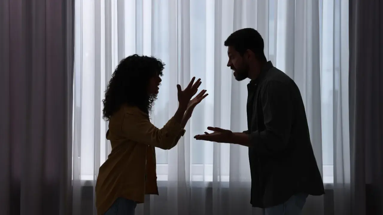 Siluetas de una pareja discutiendo apasionadamente. Ella gesticula con las manos, él la mira fijamente. ¿Será que porque atraigo a personas con problemas?