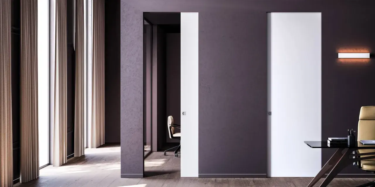 Paredes blancas y puertas de color blanco y morado oscuro, con una silla de oficina y un escritorio.