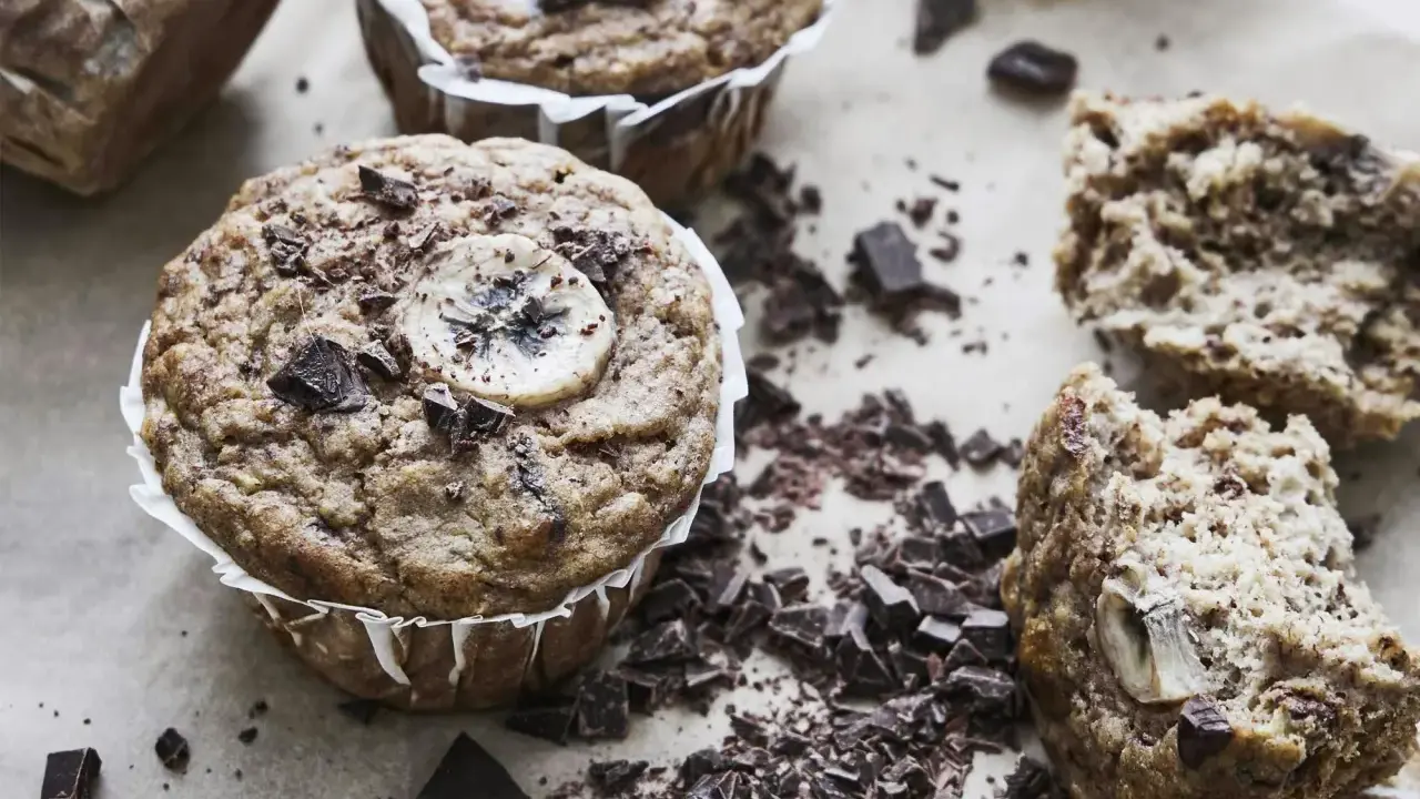 Saftiga bananmuffins med chokladbitar och en bananskiva på toppen. Perfekt för ett banan muffins recept.