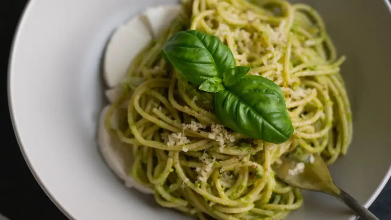Spaghetti z pesto i mozzarellą, ozdobione bazylią. Czy taki makaron jest dietetyczny? Zależy od składników!
