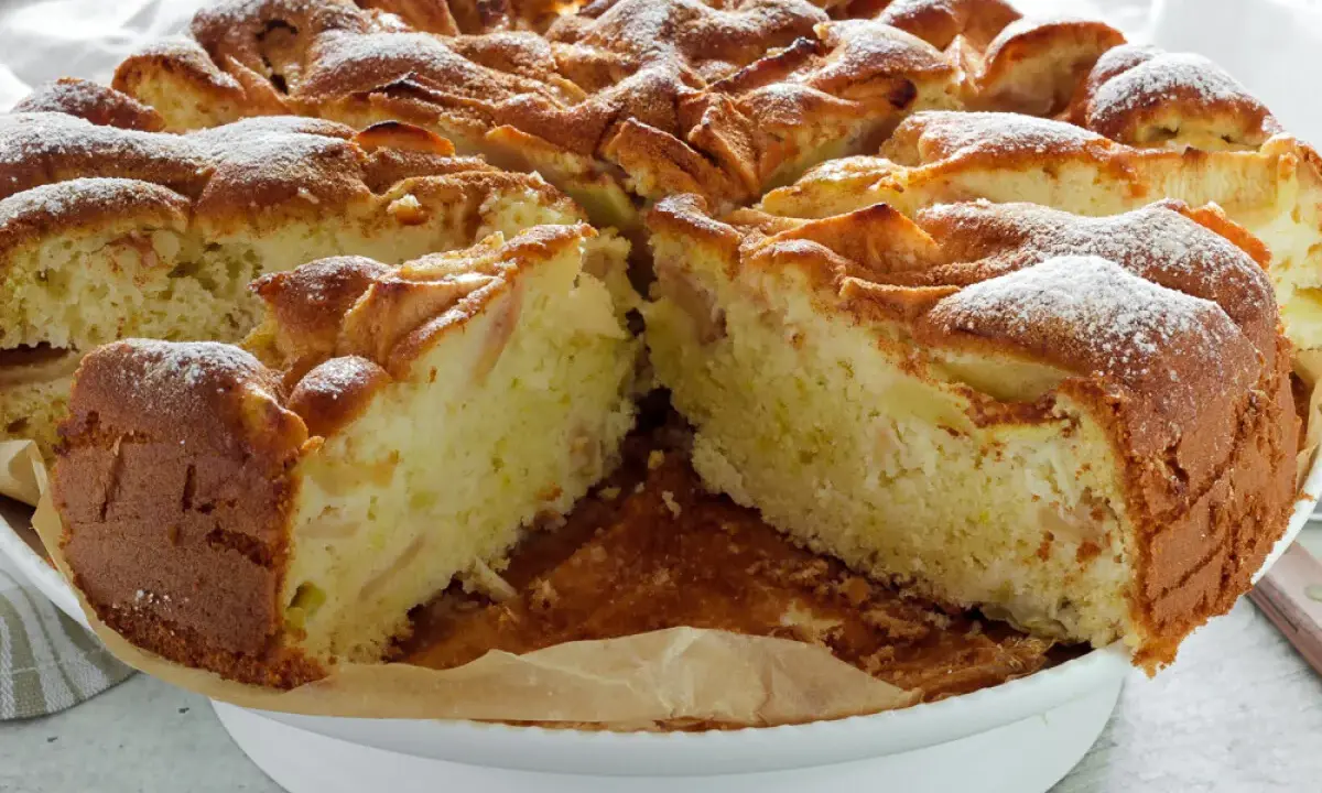 Puszyste ciasto z jabłkami na oleju i mleku, posypane cukrem pudrem. Idealne na deser.