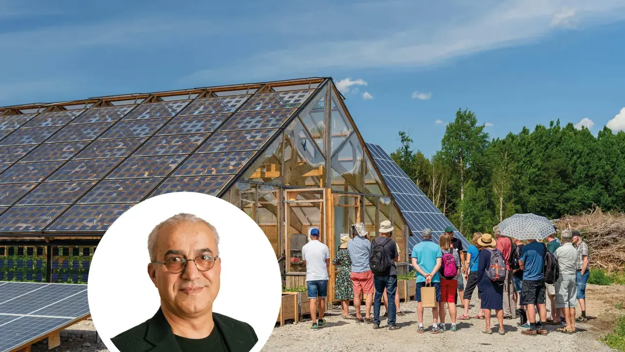 En grupp besökare tittar på ett växthus med solpaneler på taket, en del av auterra solar-projektet.