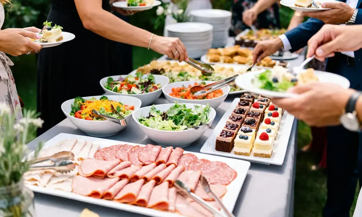 Un délicieux buffet froid avec salades fraîches, charcuteries variées et petits gâteaux colorés, prêt à régaler les convives.