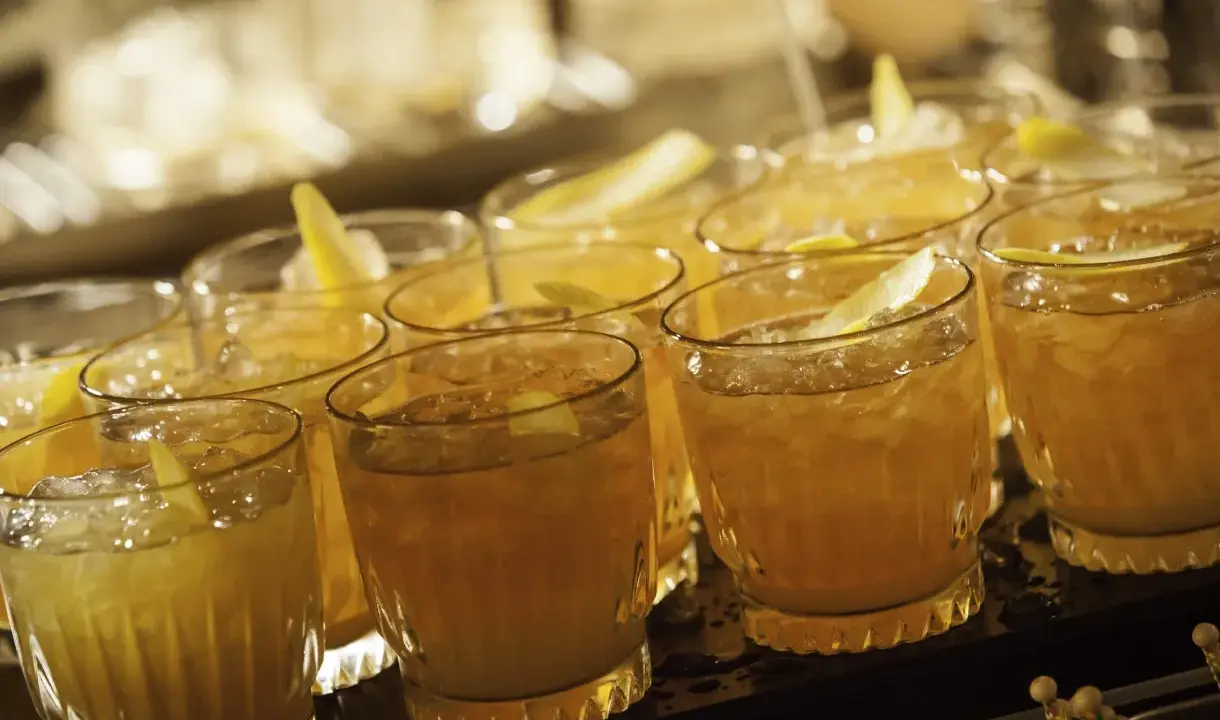 Mehrere Cognac Cocktails mit Eis und Zitronenzeste, bereit zum Servieren.