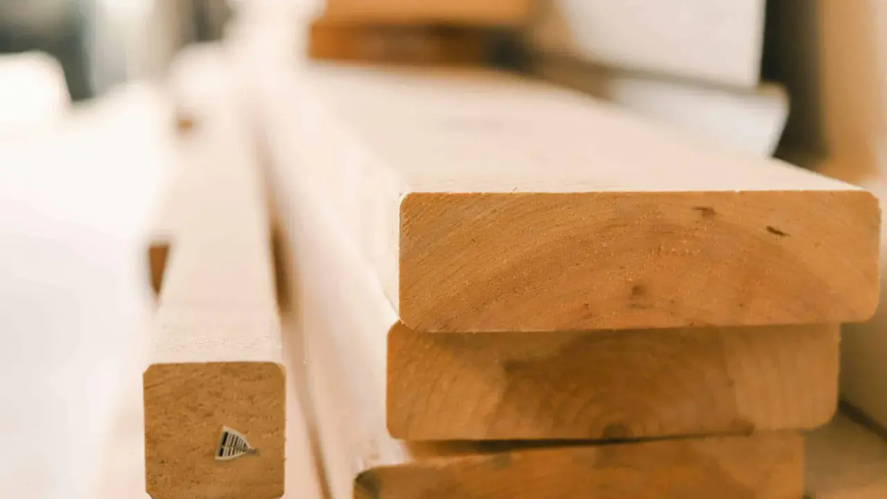 Stapel von unbehandelten Holzbrettern, bereit für den Bau eines Dach-Ringbalkens.