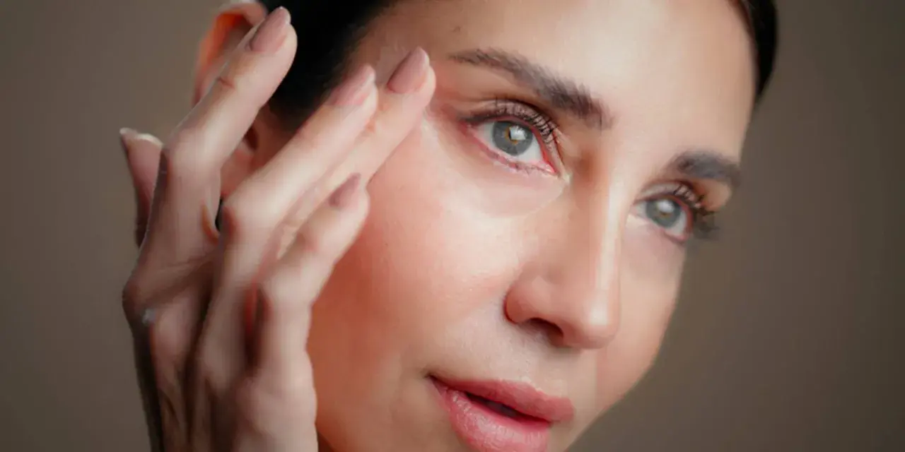 Une femme applique un soin sur son visage. Attention, l'acide hyaluronique peut parfois assécher la peau si mal utilisé.