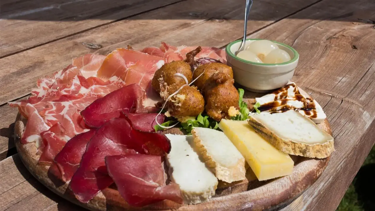 Tagliere con salumi, formaggi, frittelle e cipolline, un assaggio dei piatti tipici Valtellina.