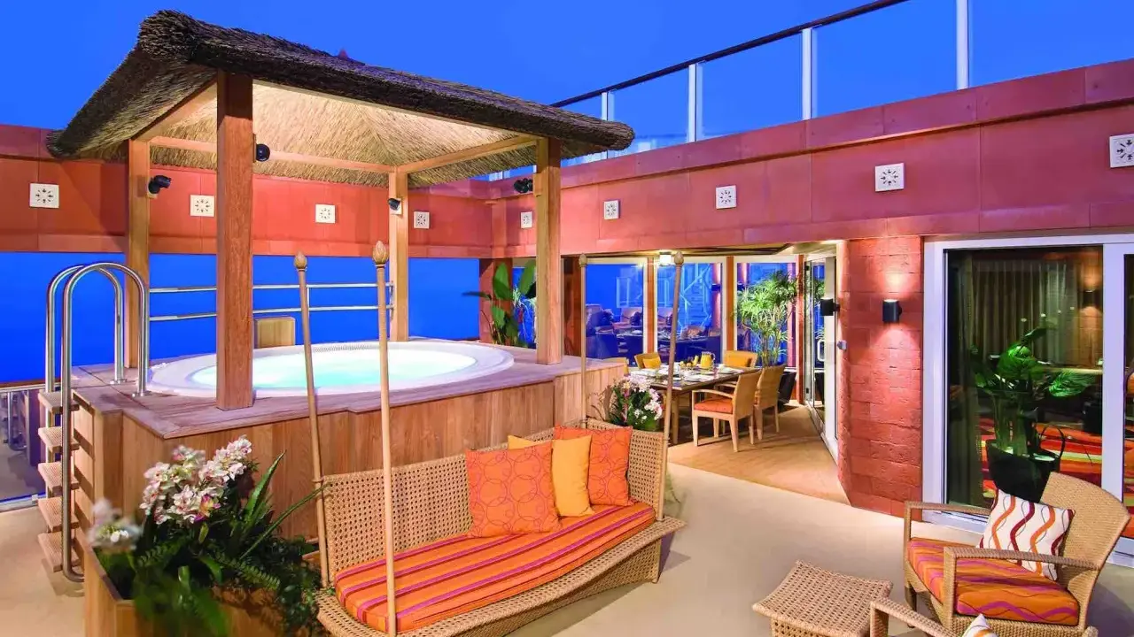 Terrazza con vasca idromassaggio e zona pranzo, un esempio di quali sono le cabine migliori su una nave da crociera.
