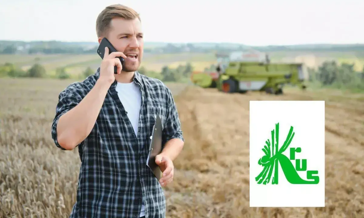 Rolnik rozmawia przez telefon na polu, planując, jak założyć firmę na krusie. W tle kombajn zbiera plony.