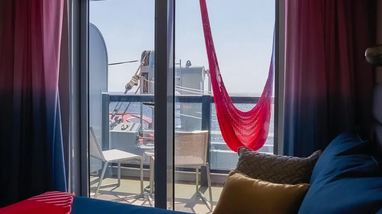 Cabina balcone vista parziale MSC con amaca rossa e cuscini accoglienti.