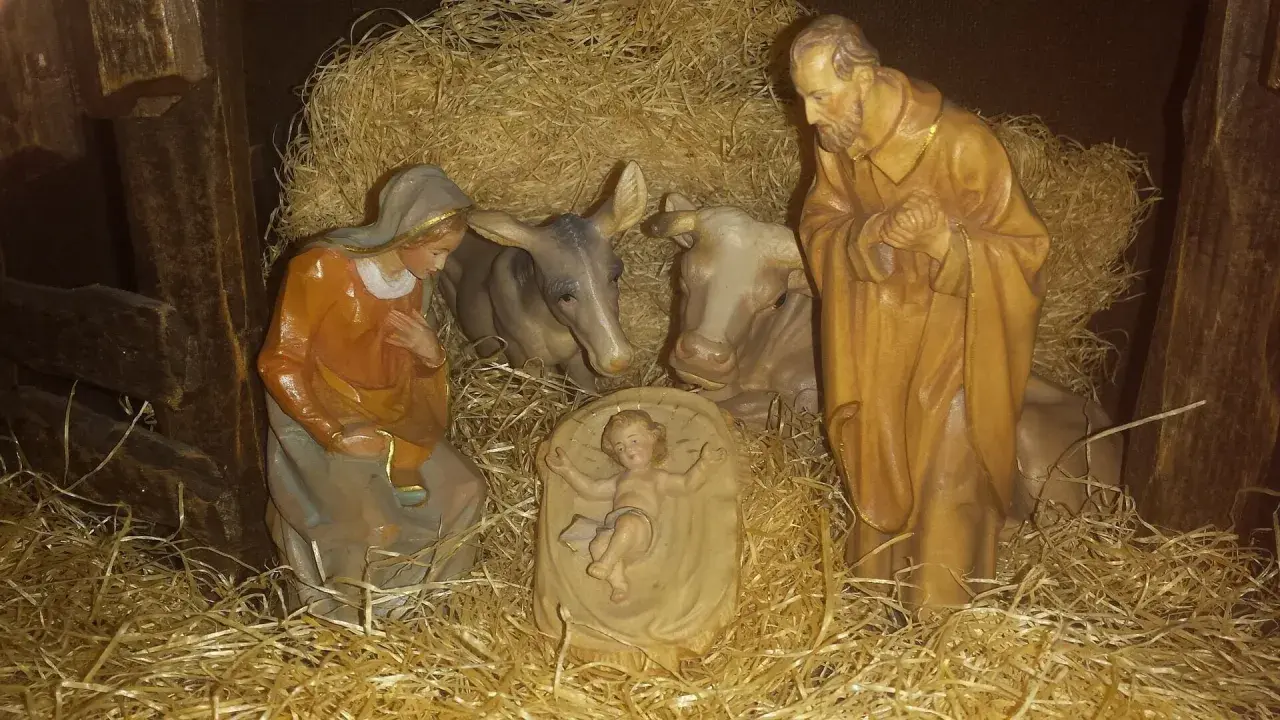 Szopka z figurkami: Maryja, Józef, Dzieciątko Jezus, wołek i osiołek. Tekst opowiada o narodzinach.