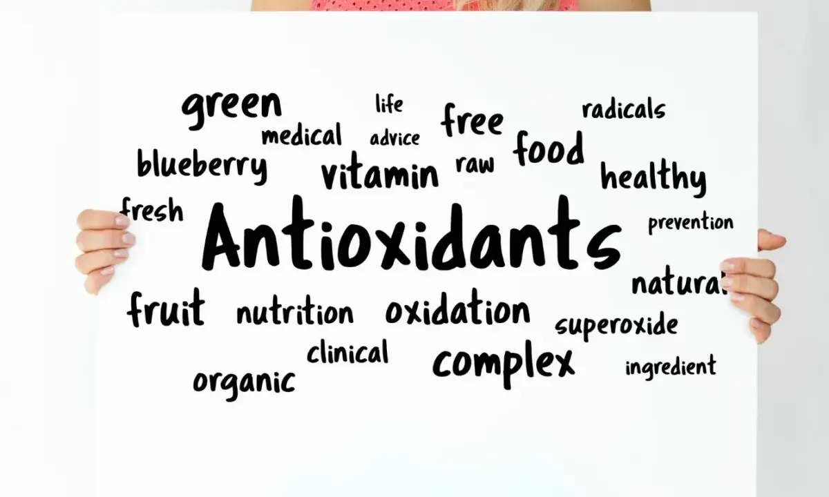 Tablica z napisem "Antioxidants" otoczona słowami kluczowymi, takimi jak "free radicals", "healthy food", "vitamin", "fruit", "blueberry".