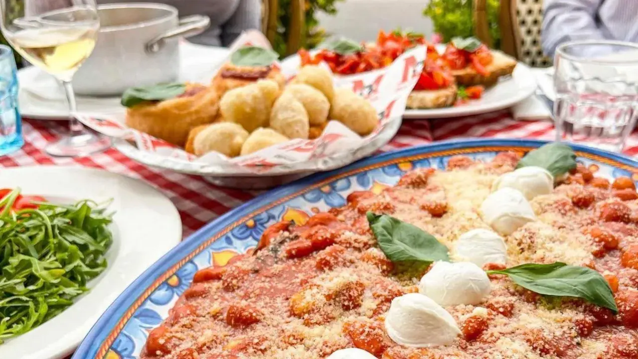 Un assaggio di cosa mangiare in Campania: gnocchi fritti, bruschette e un piatto di pasta al pomodoro e mozzarella.