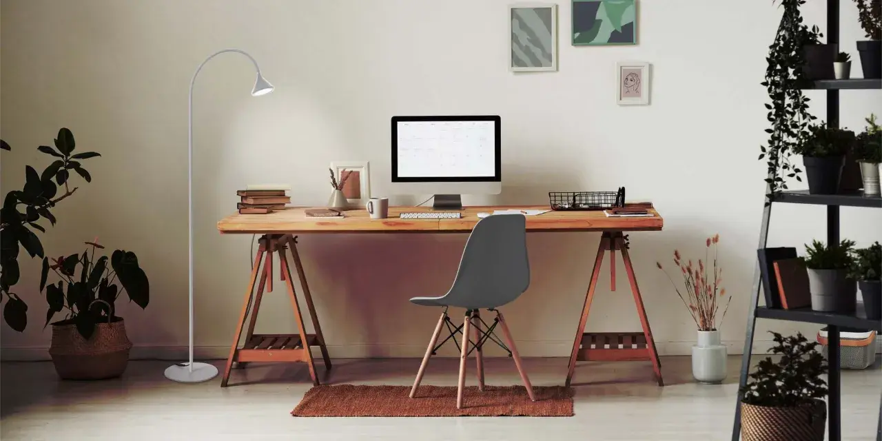 Bureau moderne pour le télétravail : bureau en bois, ordinateur, plante verte et lampe. Une belle idée bureau teletravail pour un espace fonctionnel et agréable.