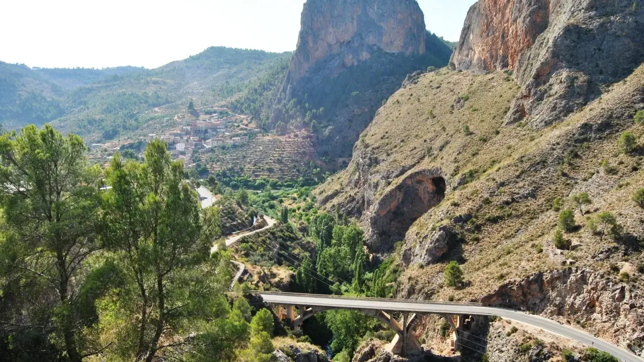 Un puente cruza un cañón con un pueblo en la ladera. El **mirador del infierno** ofrece vistas espectaculares de la garganta y las montañas.