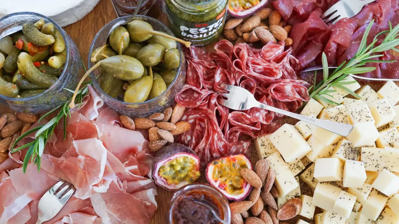 En härlig charkbricka med salami, prosciutto, ost, oliver, cornichoner och nötter. Perfekt för mingel! Här är några charkbricka tips.