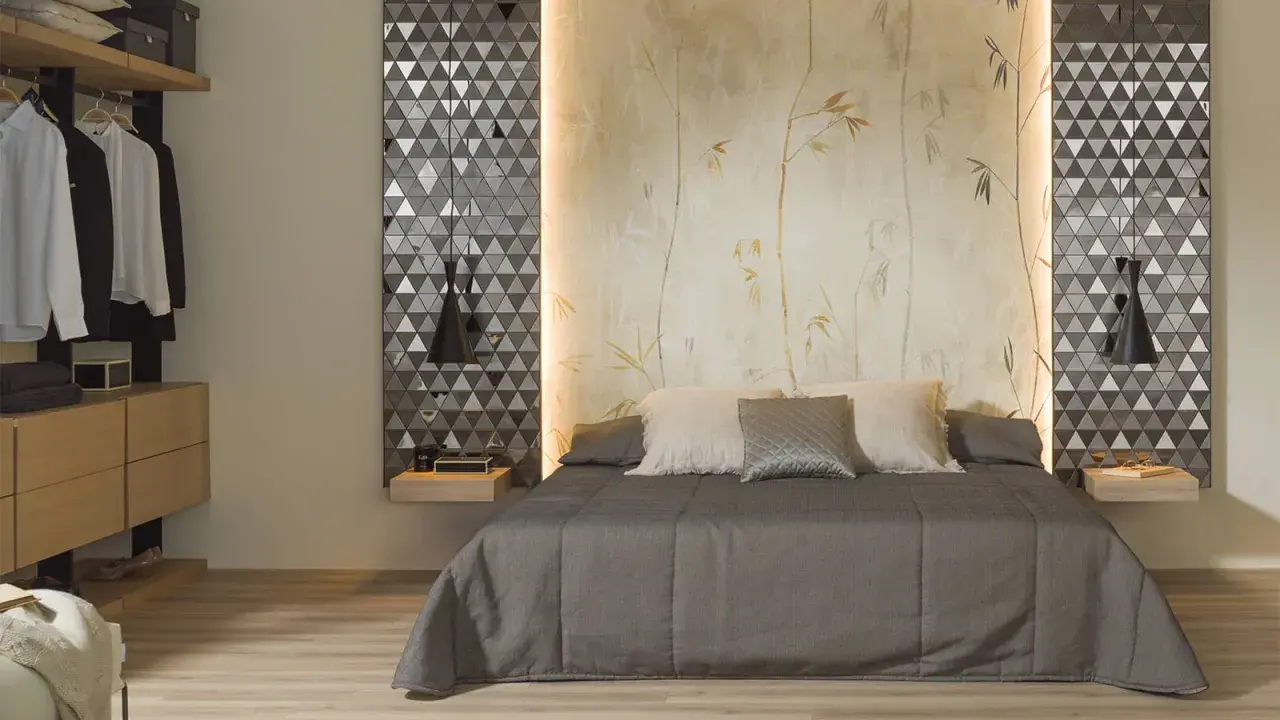 Habitaciones sin cabecero: cama con edredón gris, almohadas y papel tapiz de bambú. A la izquierda, armario abierto con ropa.