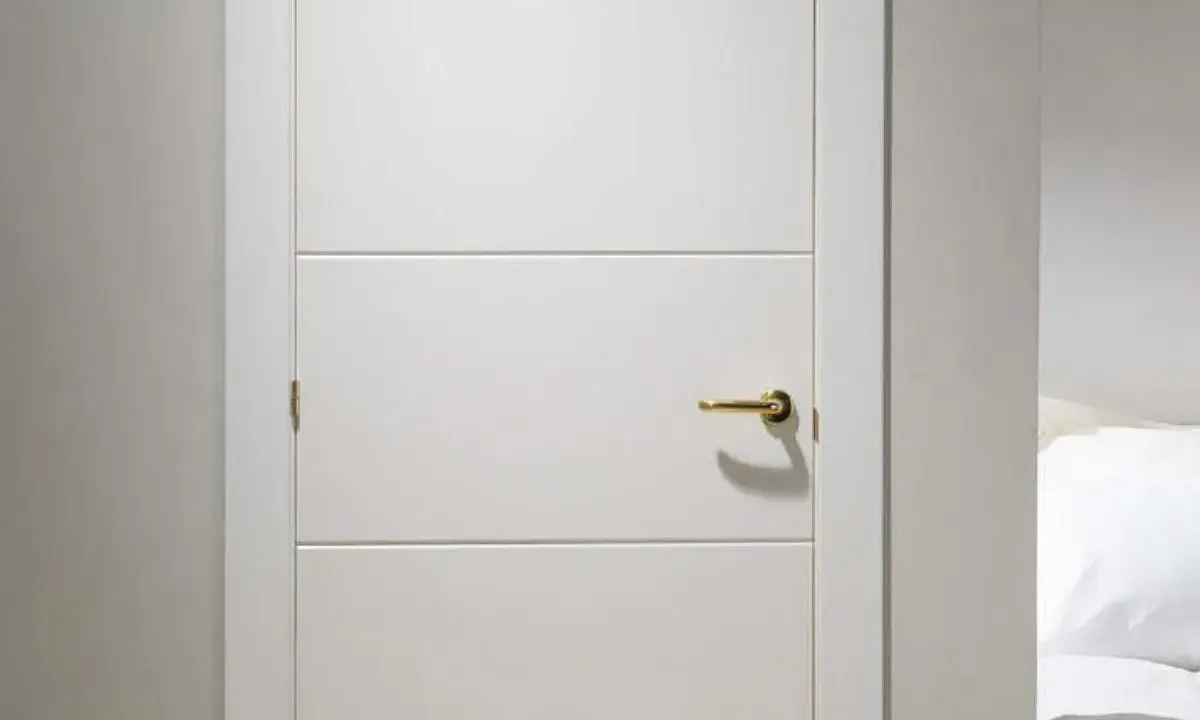 Puerta lacada en blanco con tirador dorado. Aprende como limpiar puertas lacadas en blanco para mantenerlas impecables.