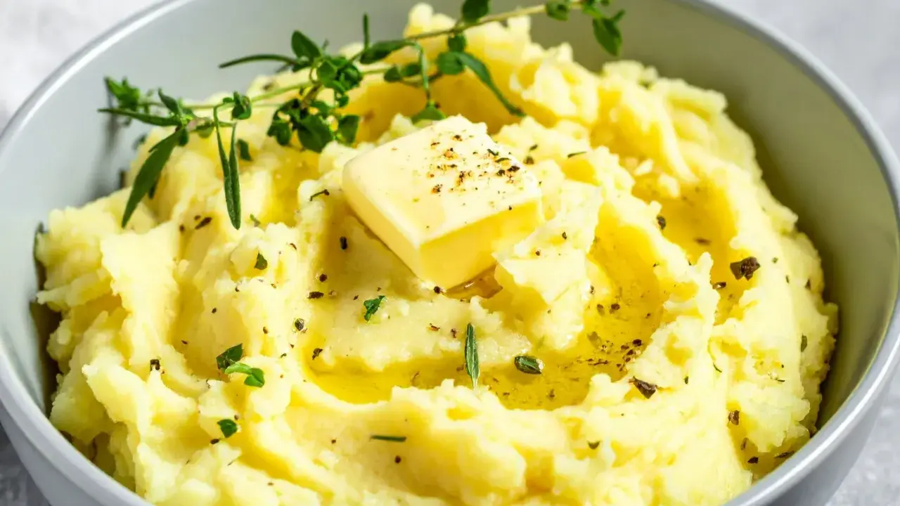 Miseczka kremowego puree ziemniaczanego z masłem, ziołami i pieprzem.