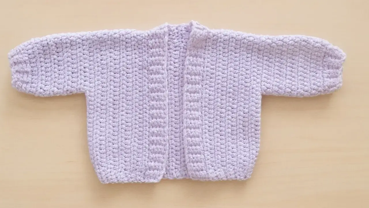 Chaqueta de bebé tejida a mano, color lila. Ideal para 6 meses, con un diseño sencillo y cálido.