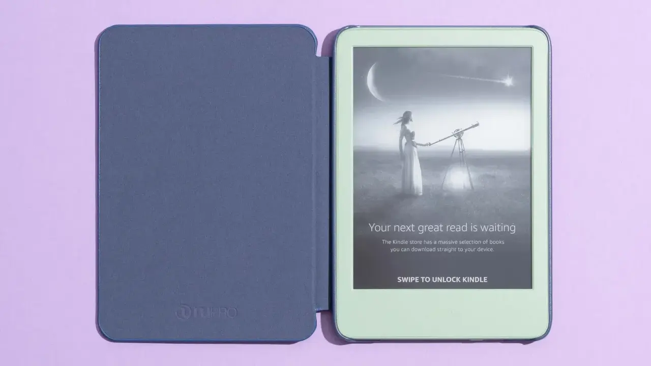 Granatowe etui na Kindle 11 obok zielonego czytnika. Na ekranie Kindle grafika z kobietą i teleskopem.
