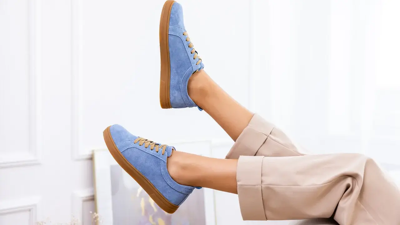 Niebieskie buty z nubuku, jak odnowić je, by wyglądały jak nowe. Stylowe sneakersy na brązowej podeszwie.