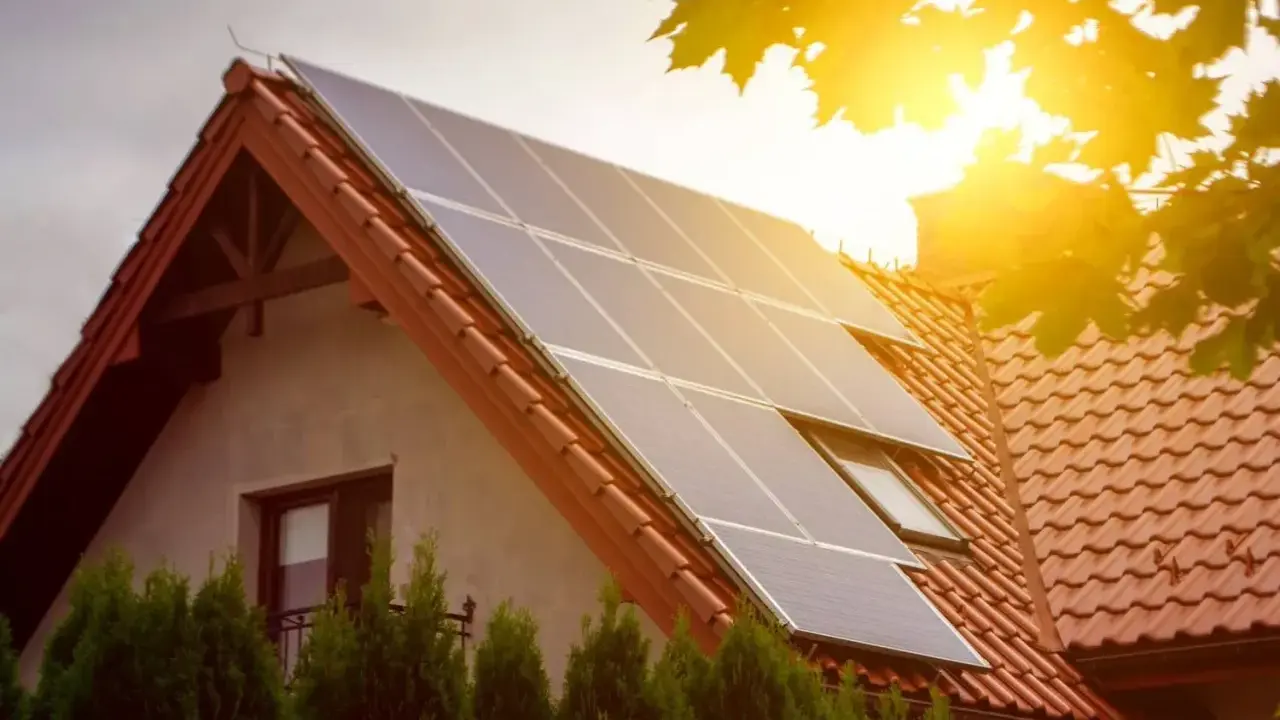 Panele słoneczne na dachu domu łapią promienie słońca, zapewniając czystą energię.