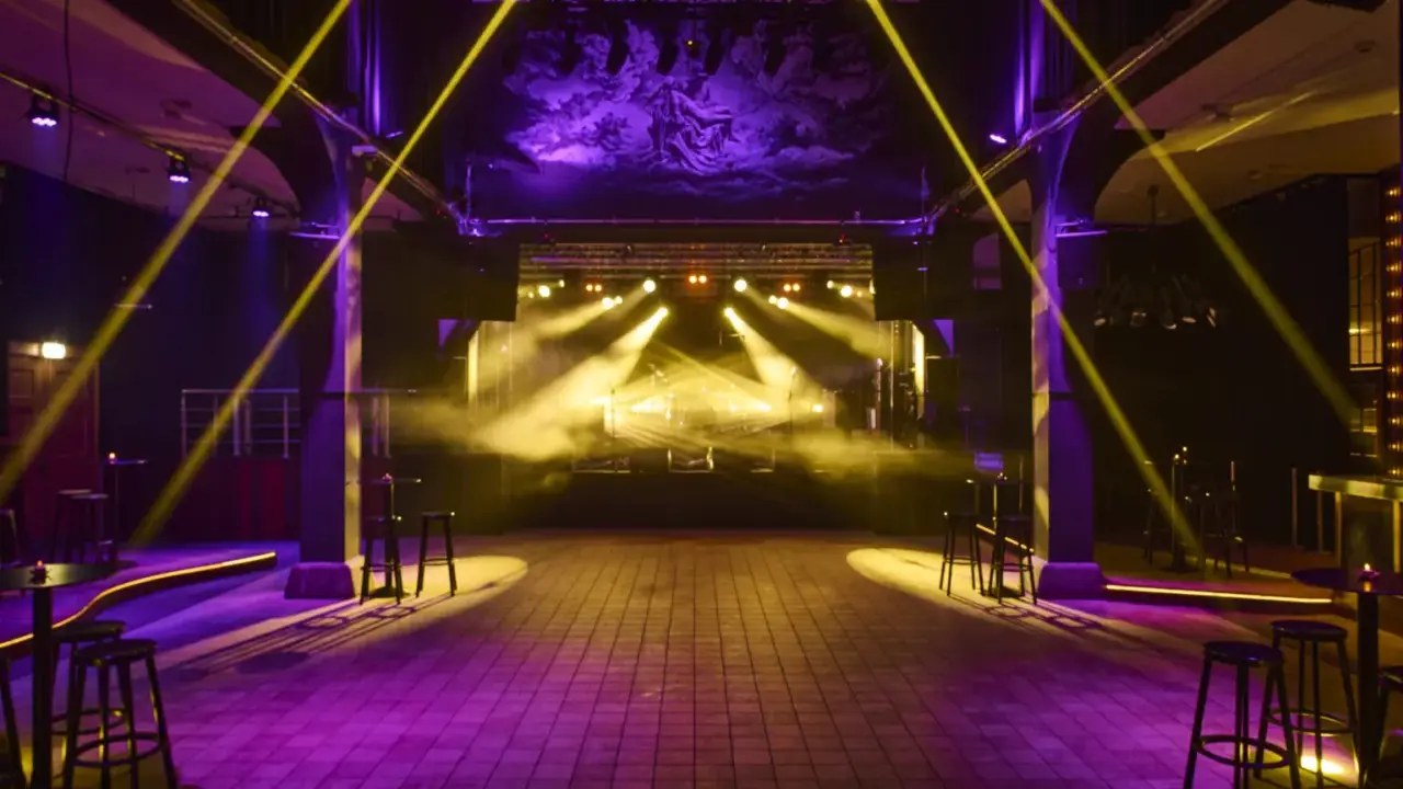 Scenljus och rök fyller en tom lokal i slakthusområdet Stockholm, redo för en kväll med musik och fest.