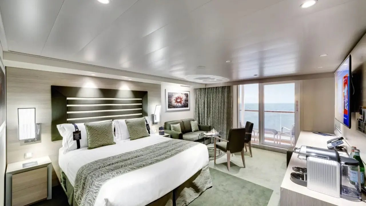 Lussuosa cabina nave con letto king-size, divano, balcone vista mare e TV.
