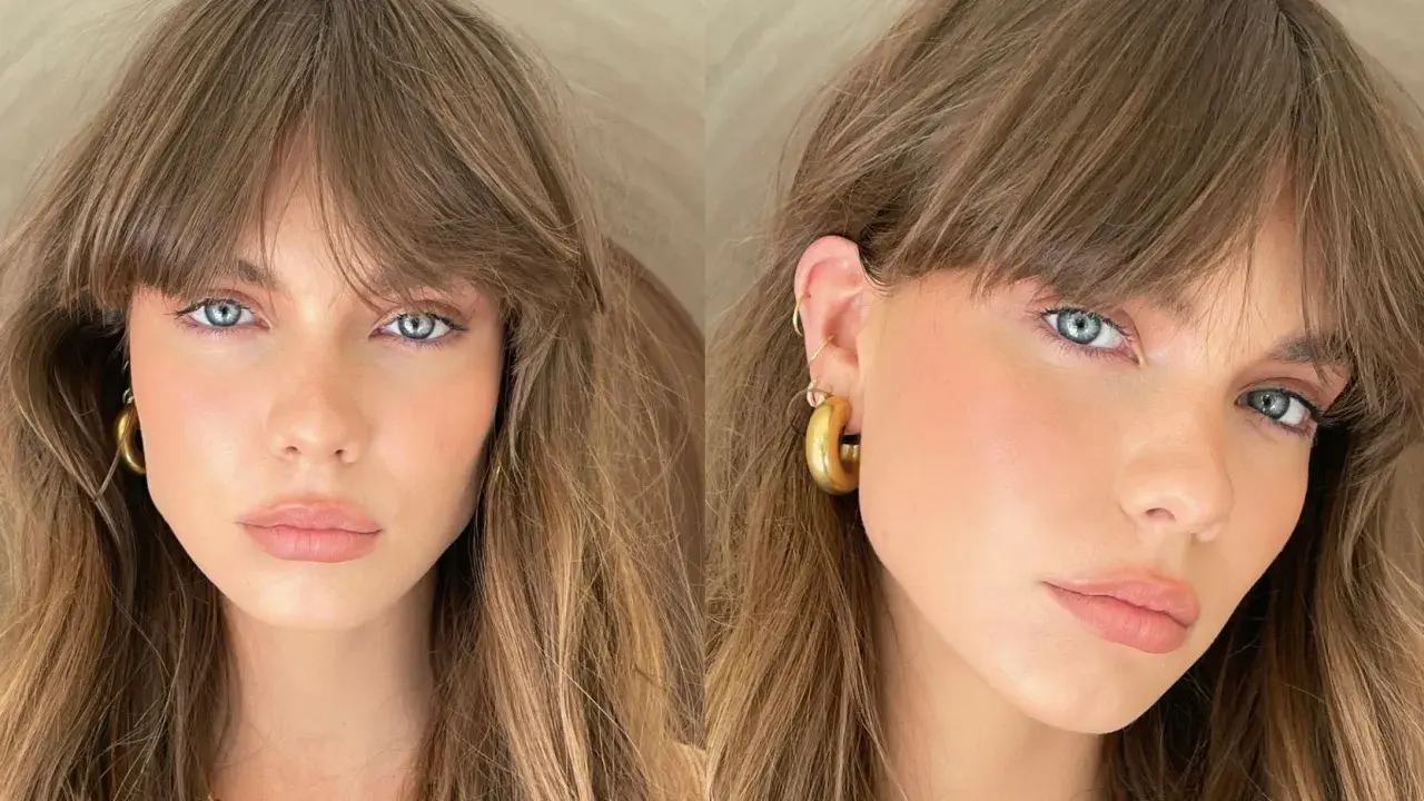 Mujer con ojos azules y cabello castaño, luciendo un "no makeup makeup look" con mejillas sonrosadas y labios naturales.