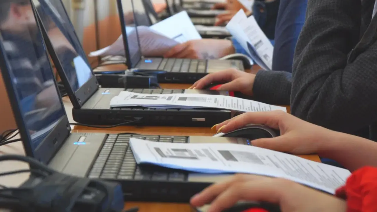 Uczniowie klasy 4 na lekcji informatyki pracują przy komputerach, korzystając z myszek i dokumentów.