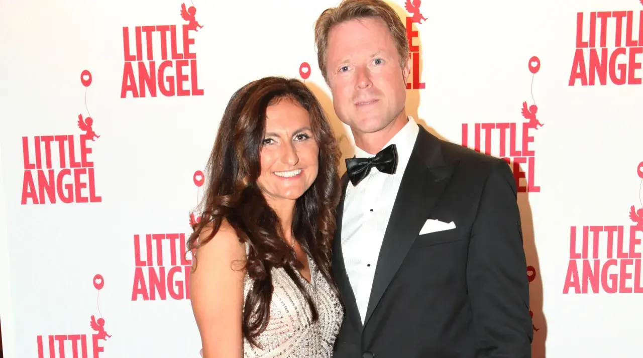 Gunilla von Platen med sin partner framför en vägg med texten "Little Angel".